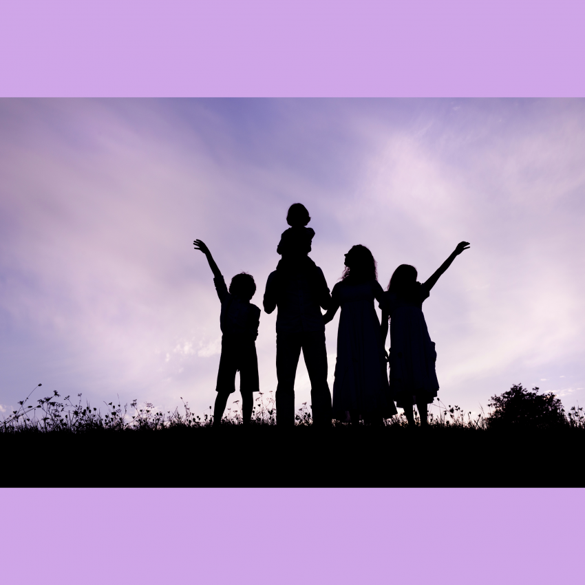 A silhouette of a family standing on a hill