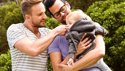 Same Sex couple holding a child